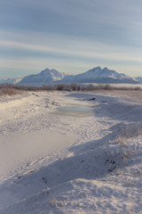 Fototapeta na wymiar Snowy hay flats and mountains in Alaska.