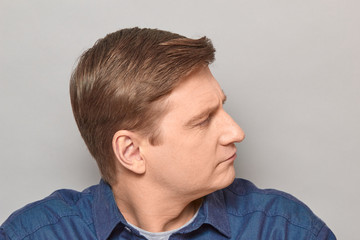 Obraz premium Portrait of confident focused blond mature man smiling slightly