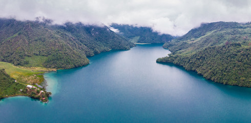 Aerial view of the Laguna Brava in Guatemala, on a cloudy day where you can see its turquoise water and the beautiful mountains that surround the lake. © Daniel Umana 😎📸