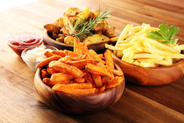 Variety of potatoes with fries. potato wedges, french fries, sweet potato for lunch on table