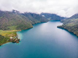 Fototapeta premium Aerial view of the Laguna Brava in Guatemala, on a cloudy day where you can see its turquoise water and the beautiful mountains that surround the lake.