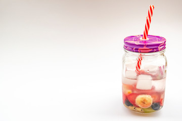 Cold iced cooling drink with strawberries and fruit in a glass jar (mug) on a white background