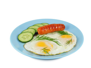 Breakfast of crambled eggs with fried sausage, fresh sliced cucumber and dill on blue plate isolated on white background, side view.