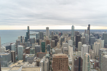 aerial view of chicago, showing some of the tallest buildings in the city. You can also see the lake and in the background you can see the sunset