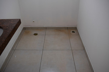 Interior de banheiro com buraco para instalação de sanitário