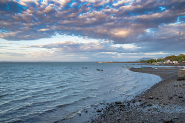 Beach on a cloudy day with storm clouds and small waves, El Salvador