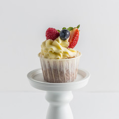 Biscuit sweet raspberries, strawberries and blueberries muffins on white.