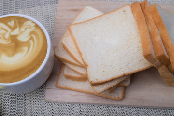 Top view Homemade slide bread with hot coffee cup on the wooden.