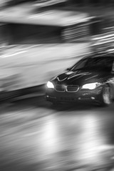 Obraz na płótnie Canvas Motion of a Black Car, Sedan, in the Street at Night, traffic, movement