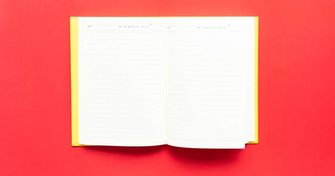 4K top view Stop motion open diary paper book on red background.