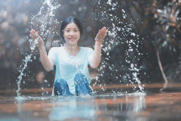 Fototapeta premium Young girl playing water stream