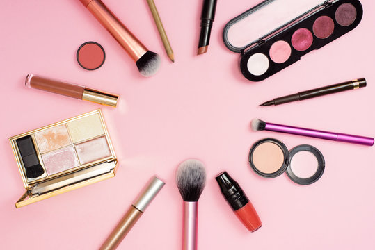 Makeup in close view. A lot of Cosmetics for woman on the backgroud. Cosmetics is stacked in a circle on the pink backgroud