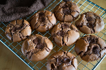 soft dark chocolate brownie cookies on a metal rack on a wooden background.