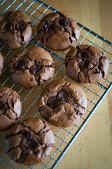 soft dark chocolate brownie cookies on a metal rack on a wooden background.