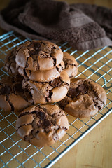 soft dark chocolate brownie cookies on a metal rack on a wooden background.