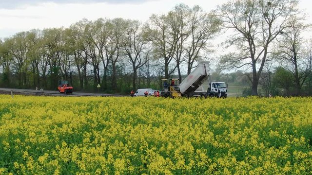 4K video. Side view of road works with asphalt paver