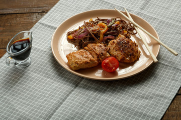 Buckwheat soba noodles with vegetables and Asian-style chicken chop on a linen napkin.