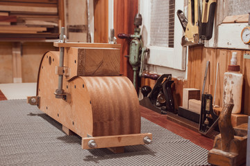 a guitar side mold, mahogany guitar side attached with, stays on the workbench in luthiery workshop