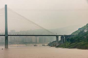 Fengdu, Chongqing, China - May 8, 2010: Yangtze River. 1 of 2 Pylons of suspension road bridge over...