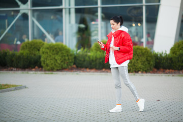 Pretty woman doing fitness outdoors listening to music