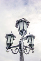 Fototapeta na wymiar Frozen and frosty lantern posts with ice and snow
