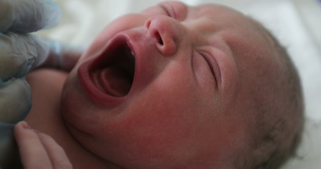  Infant newborn baby crying after birth, first seconds of life