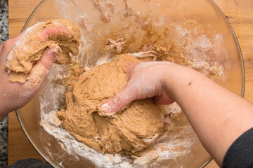 Fototapeta premium Woman's hands kneading whole wheat dough