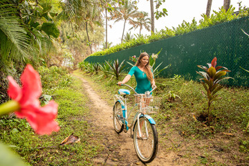 A young girl riding her bicycle on a rural road in a tropical area of Kauai in Hawaii. 