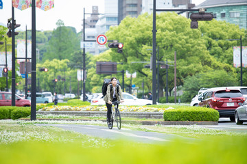 自転車で荷物の配送を行う若い女性