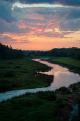 Beautiful sunset over a river with green bushes