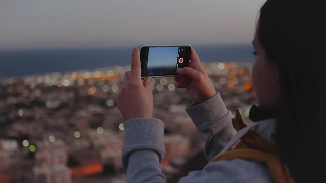 Woman take picture of the sea by smartphone in the evening close-up, Woman stay on top of the mountain and looking Into Horizon, 4k