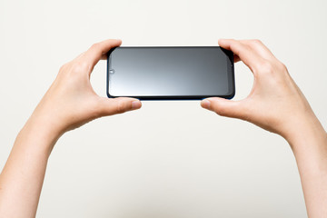 female hand holding mobile phone in interior