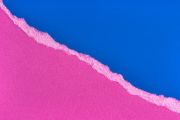 Torn purple paper edge on blue background. Ripped paper piece edge isolated with soft shadow.