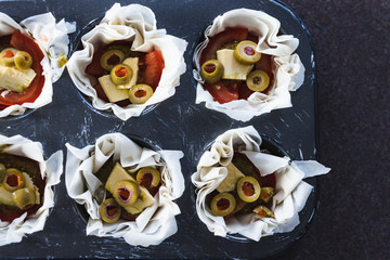 plant-based food, filo pastry cups with vegan filling made of tomatoes olives pesto and dairy-free cheese