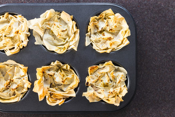 plant-based food, filo pastry cups with vegan filling in muffin tray just out of the oven