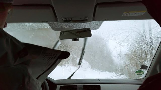 Wipers clearing a fog covered windshield, driving up a wintery road, Silvretta Montafon Ski Arena, Slow motion