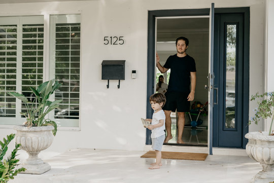 Young man in front of a door with toddler