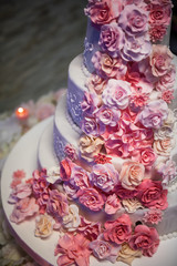White wedding cake with pink roses around it