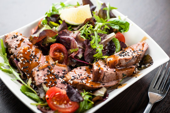 Salad with duck, sesame, cherry tomatoes and other