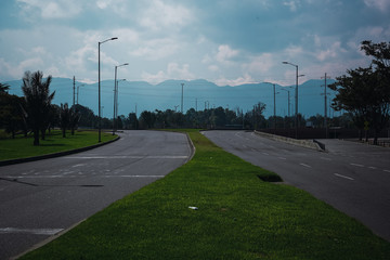 car-free street for quarantine with mountains in the background and lots of clouds
