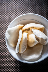 Salty rice chips in white bowl
