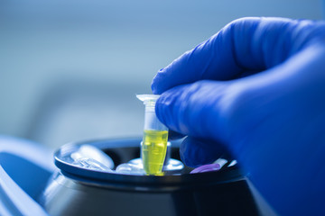 Close up of hand scientist is loading a sample to mini centrifuge in laboratory, Concept science and technology, Science background