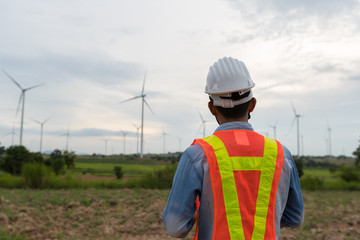 Picture of asian male electrical engineer working at wind turbine power generator station