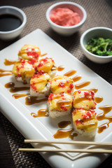 Hot sushi fritter maki on a white plate