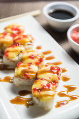Hot sushi fritter maki on a white plate