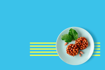 Tasty eastern sweets kozinaki made from peanuts and honey on a plate on a blue background.