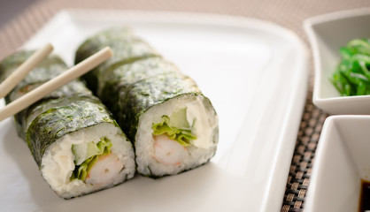 Sushi uramaki rolls with tiger prawns, cucumber