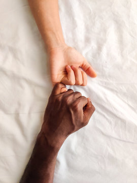 Black Male and White Female holding and touching hands of each other together