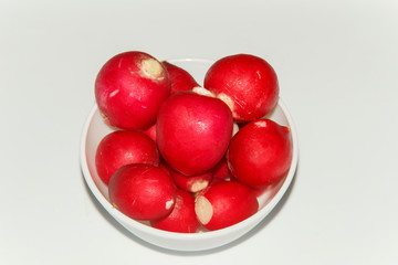   early spring red radish in a small plate, closeup 