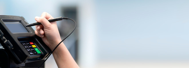 closeup female hand sign and pay money by credit card cashier counter cashless business payment process business ideas concept with abstract blur image background copyspace